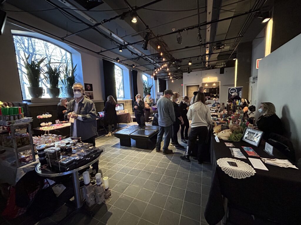 View of the Café entrance with people and booths all around.