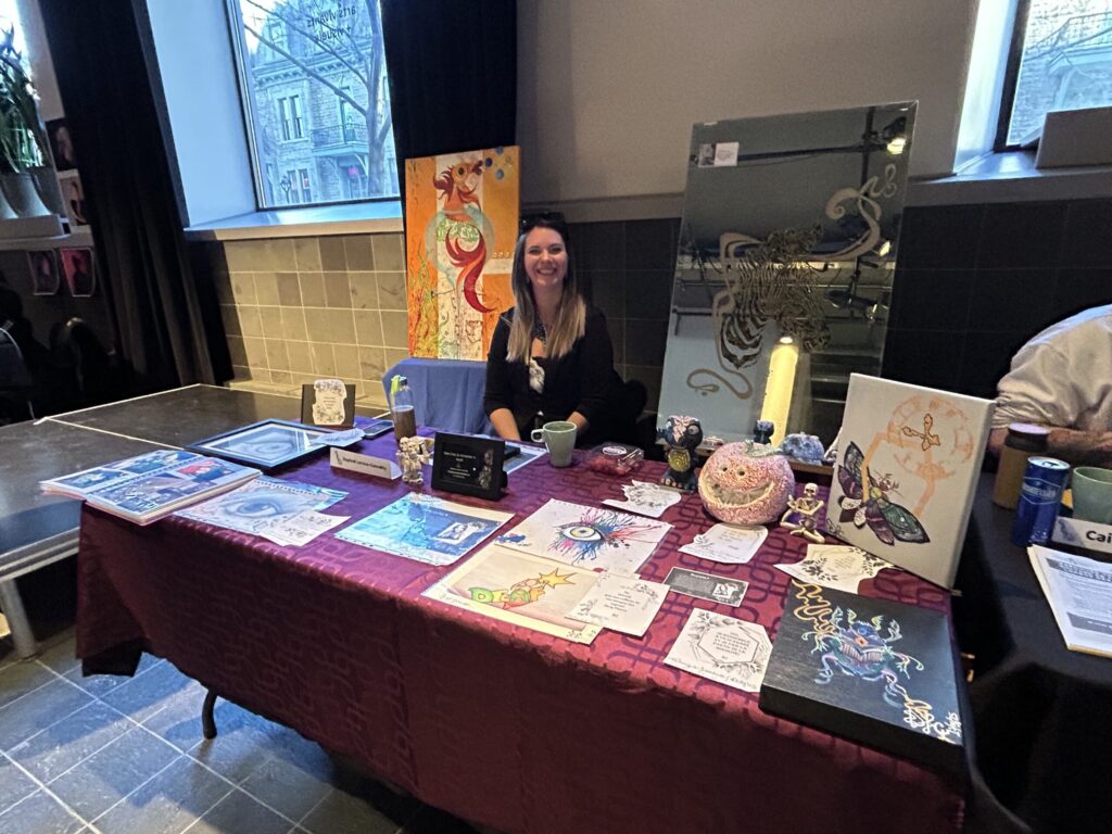 Daphné Leroux-Connolly's booth with a spread of traditional artwork and photos.